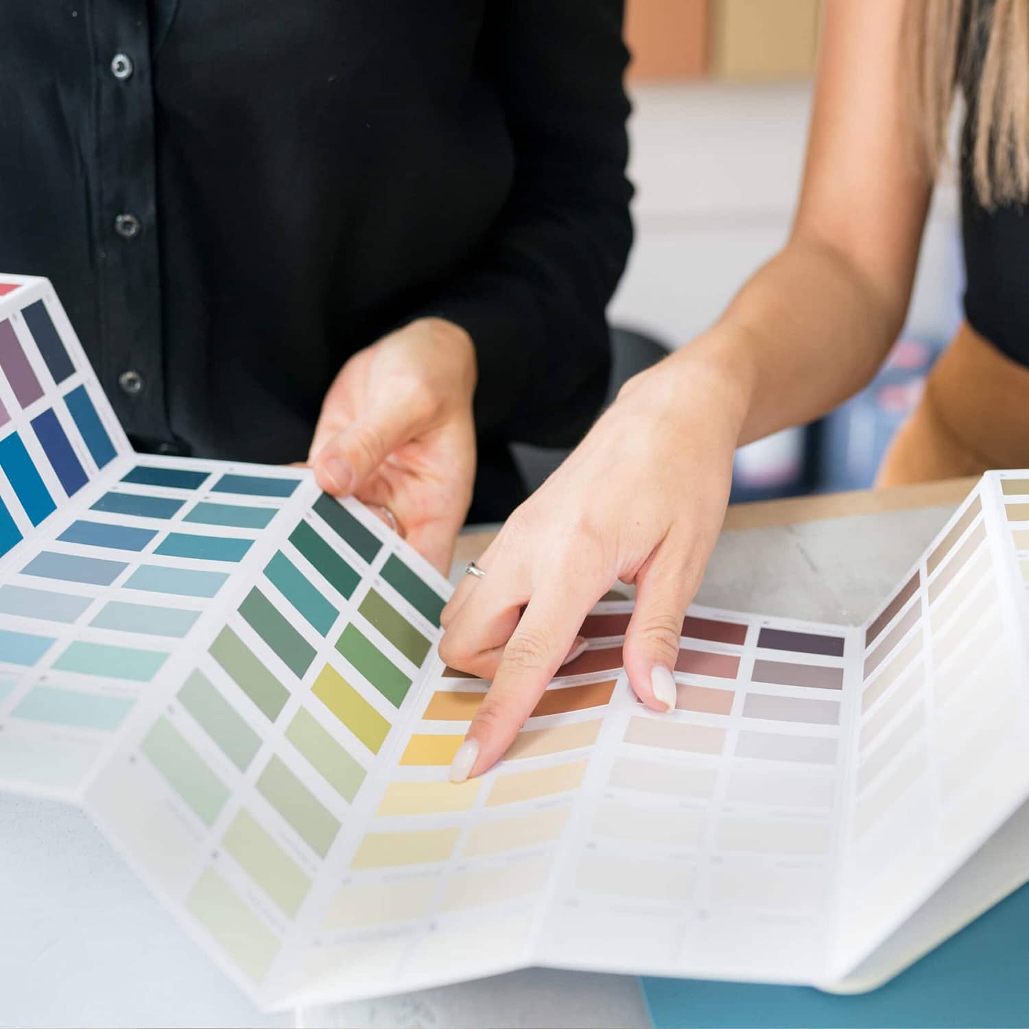 A color consultant points out a swatch to a client.